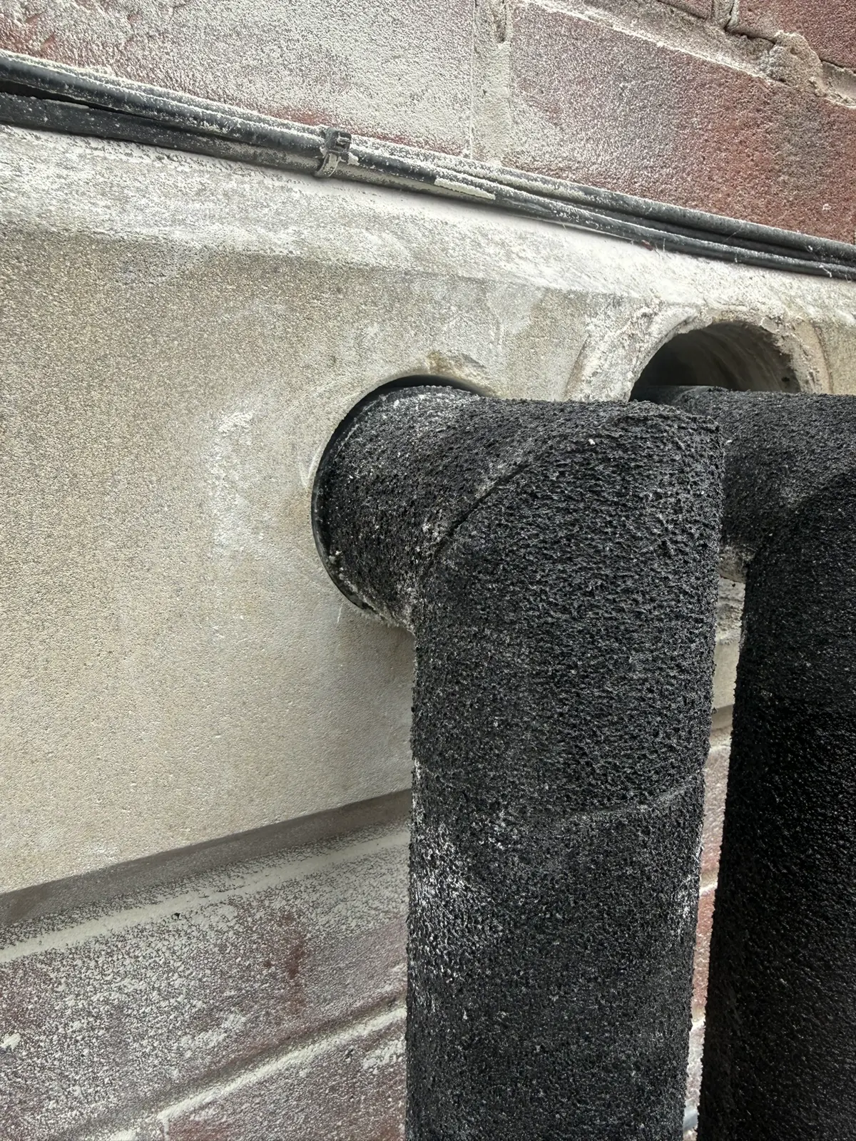 Insulated heat pump pipework entering the property